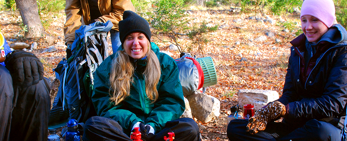 Hikers smiling and taking a rest bundled in warm clothing